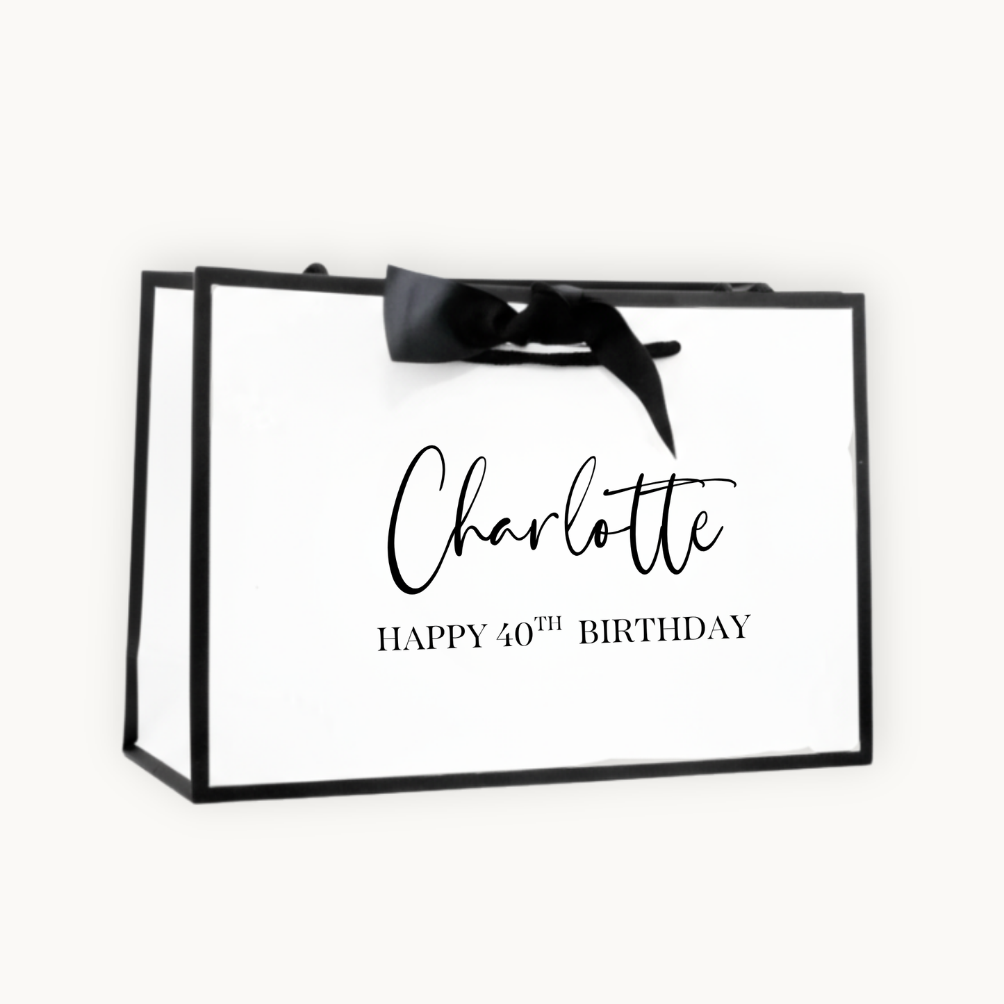 Luxury white gift bag with black border and tied with black ribbon. printed with Charlotte, Happy 40th Birthday