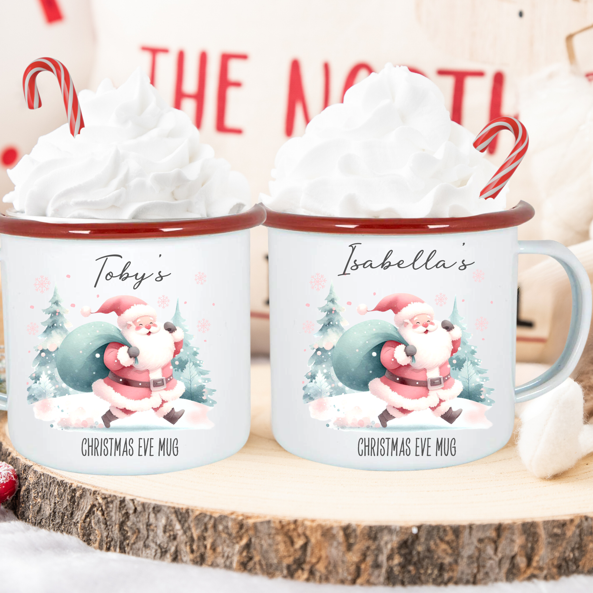 Two Christmas-themed mugs with Santa Claus design on a wooden surface.