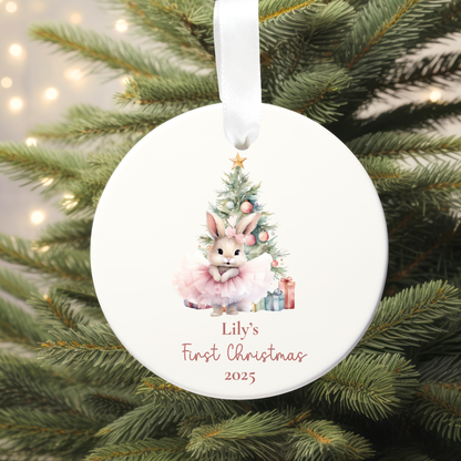 Round Christmas ornament with a rabbit and tree design, hanging on a decorated tree.