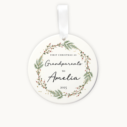 Round ceramic ornament with greenery design and text on a white background