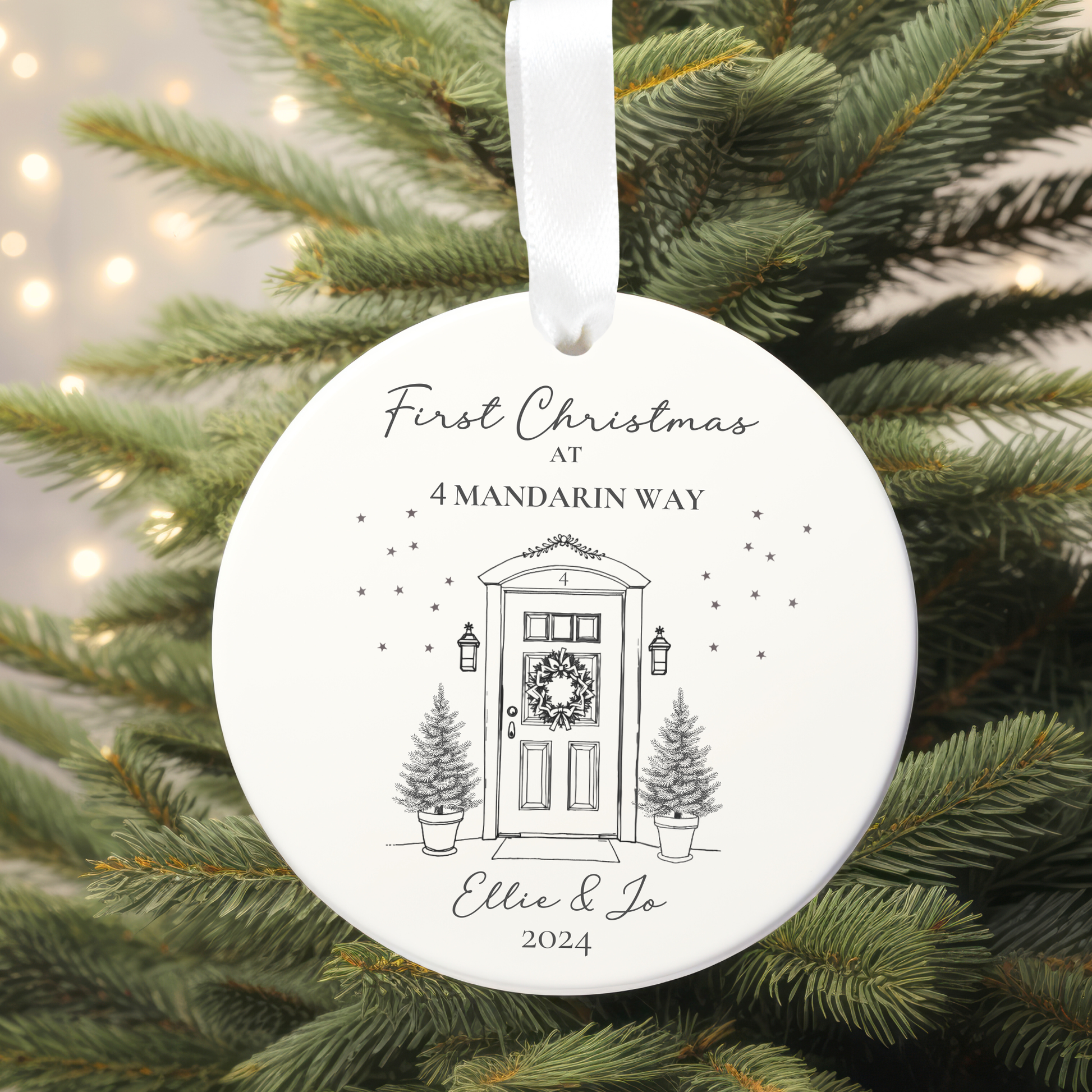 Round Christmas ornament with a door and tree design, hanging on a tree.