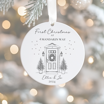 Round Christmas ornament with a door illustration and text, hanging on a tree.