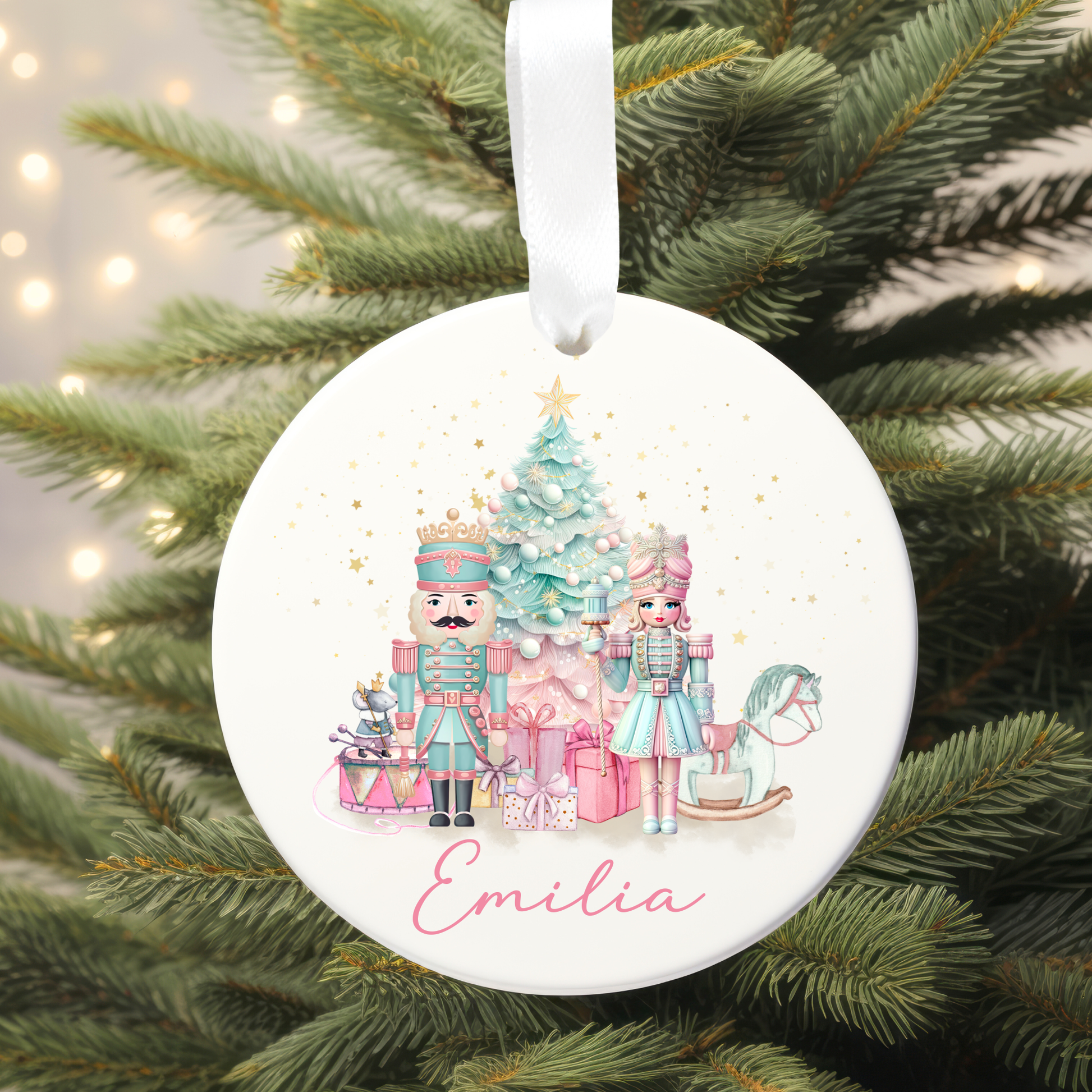 Round Christmas ornament with Nutcracker design and 'Emilia' text, hanging on a tree.