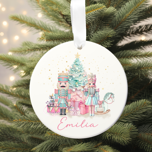 Round Christmas ornament with Nutcracker design and 'Emilia' text, hanging on a tree.