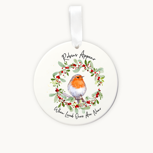 Round ceramic ornament with a robin and mistletoe design on a white background