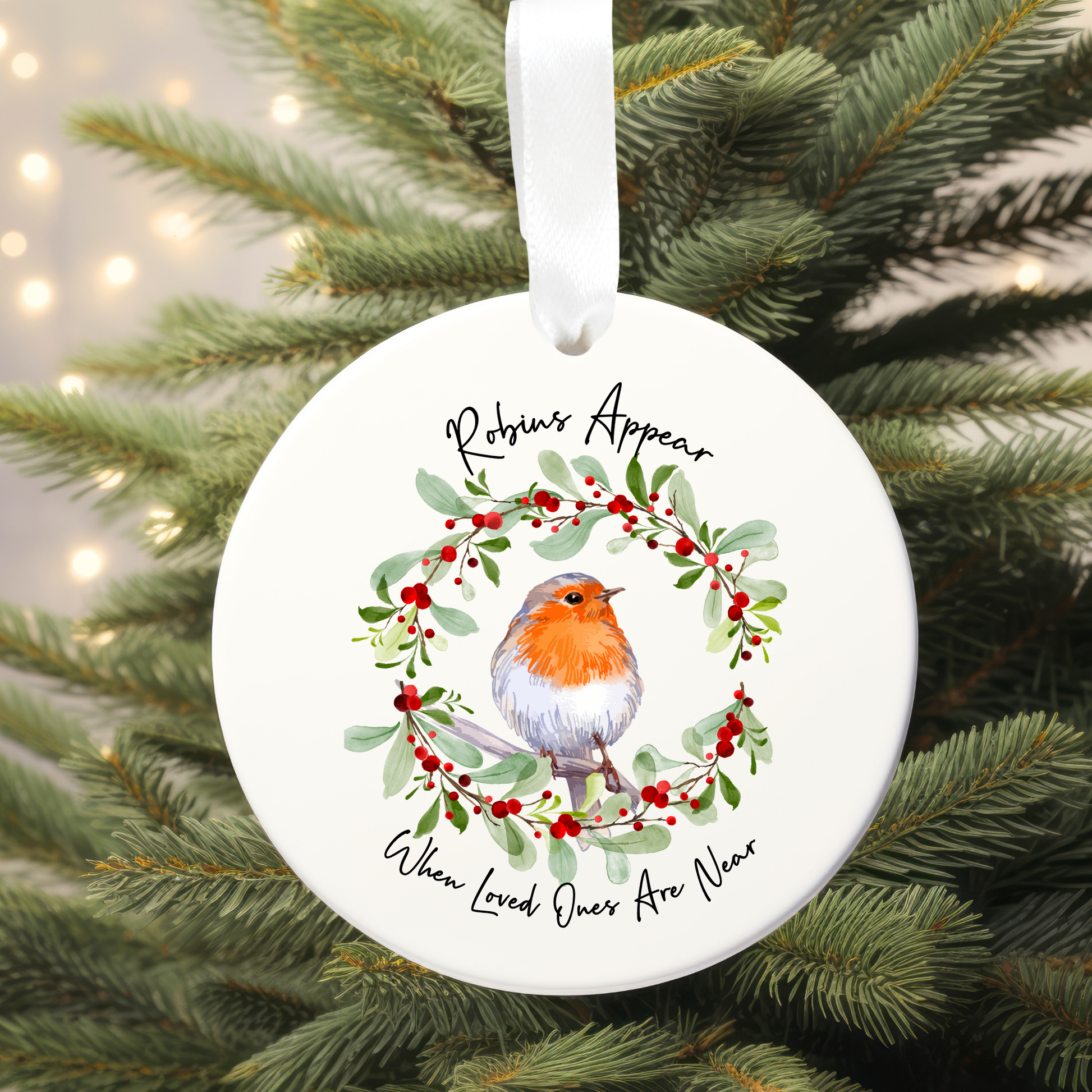 Round Christmas ornament with robin and wreath design on a tree