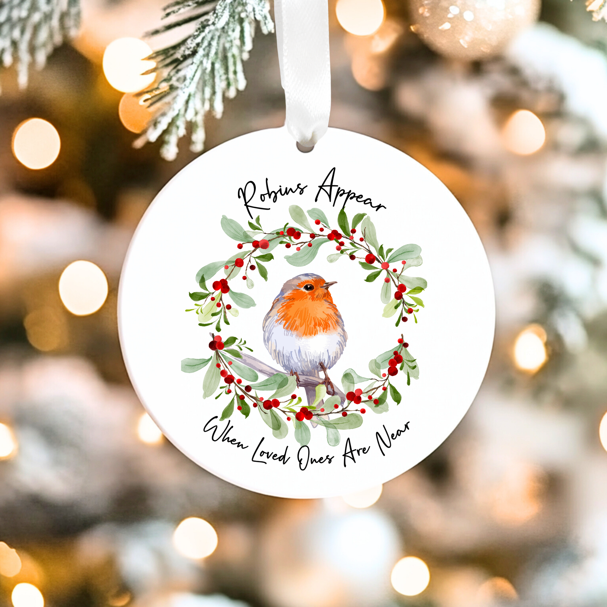 Christmas ornament with robin and wreath design on a blurred Christmas tree background