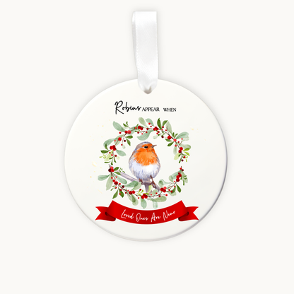 Round Christmas ornament with a robin and wreath design on a white background