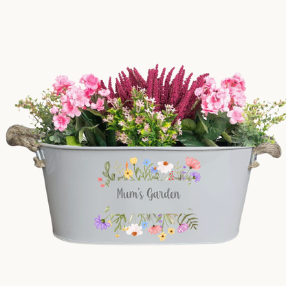 Decorative metal planter with flowers and 'Mum's Garden' text on a white background