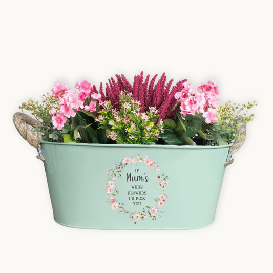 Mint green planter with flowers and decorative text on a white background