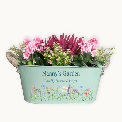 Decorative planter with flowers and 'Nanny's Garden' text on a white background