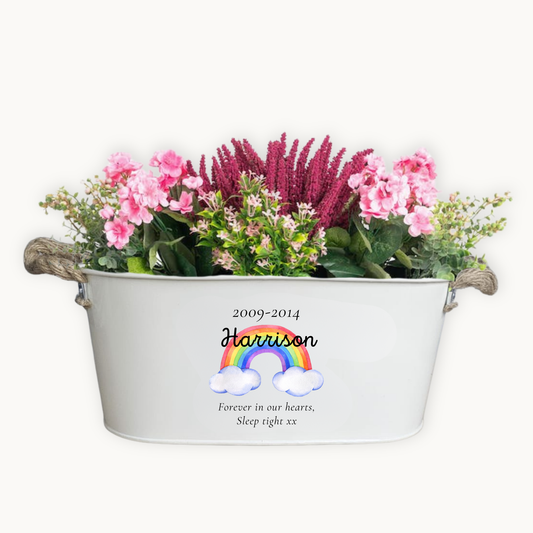 Decorative planter with flowers and personalized text on a white background