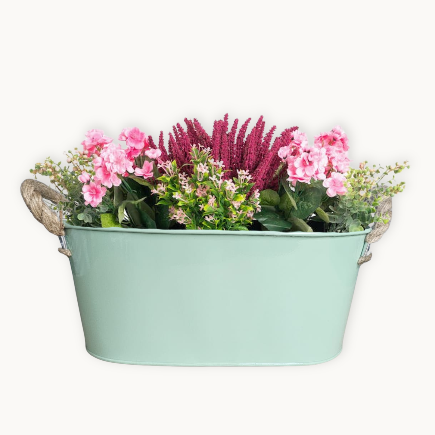Decorative sage green metal planter with plants on white background