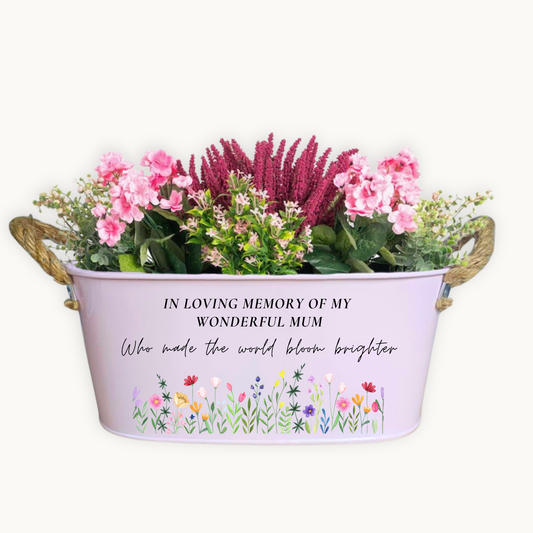 Floral arrangement in a decorative memorial container with a message on a white background