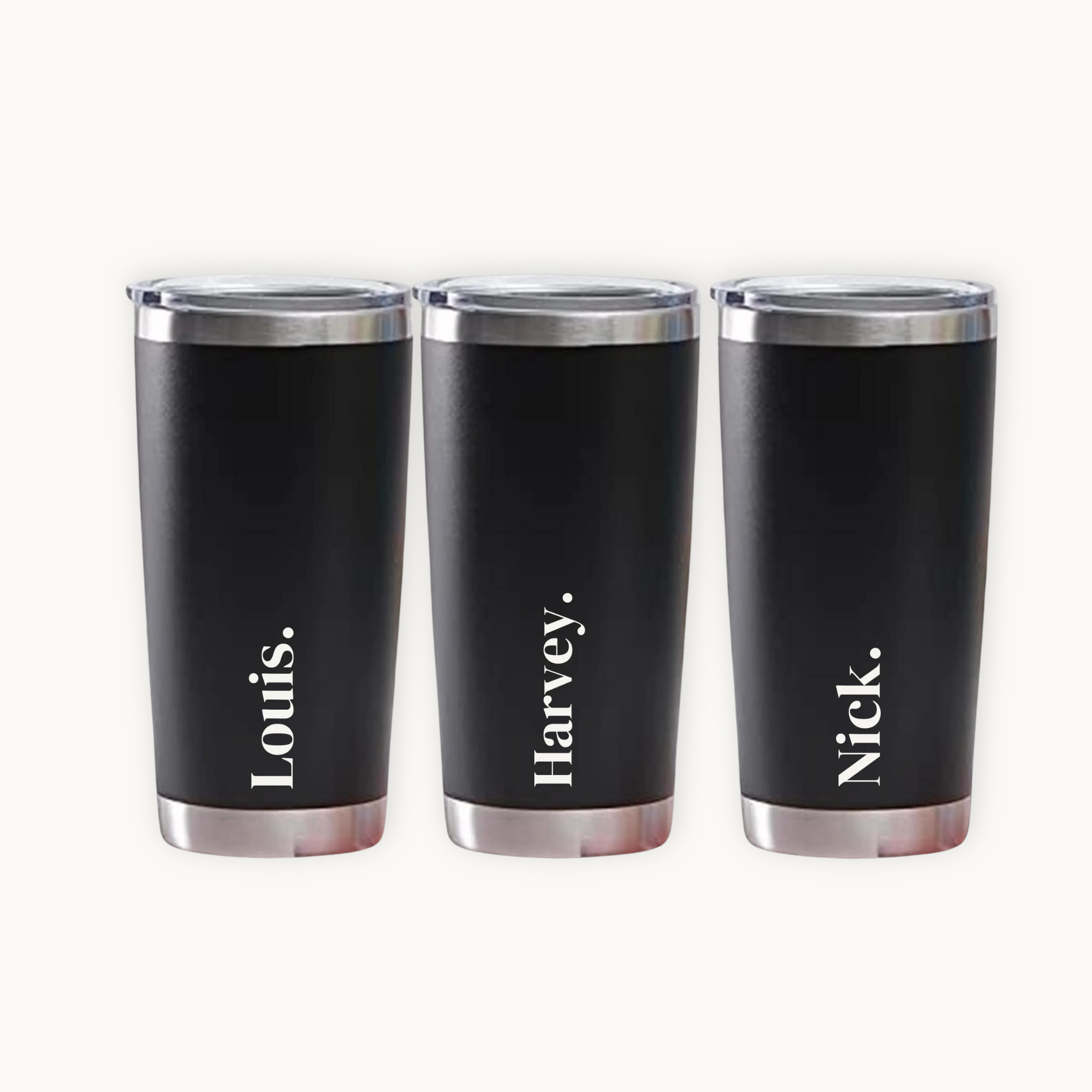 Three black tumblers with silver rims and names engraved on a white background
