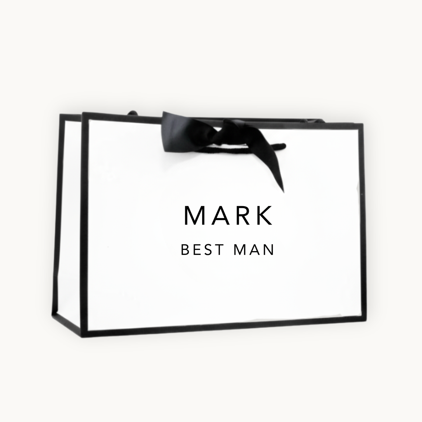 white gift bag with black border and black ribbon printed with the words Mark Best Man