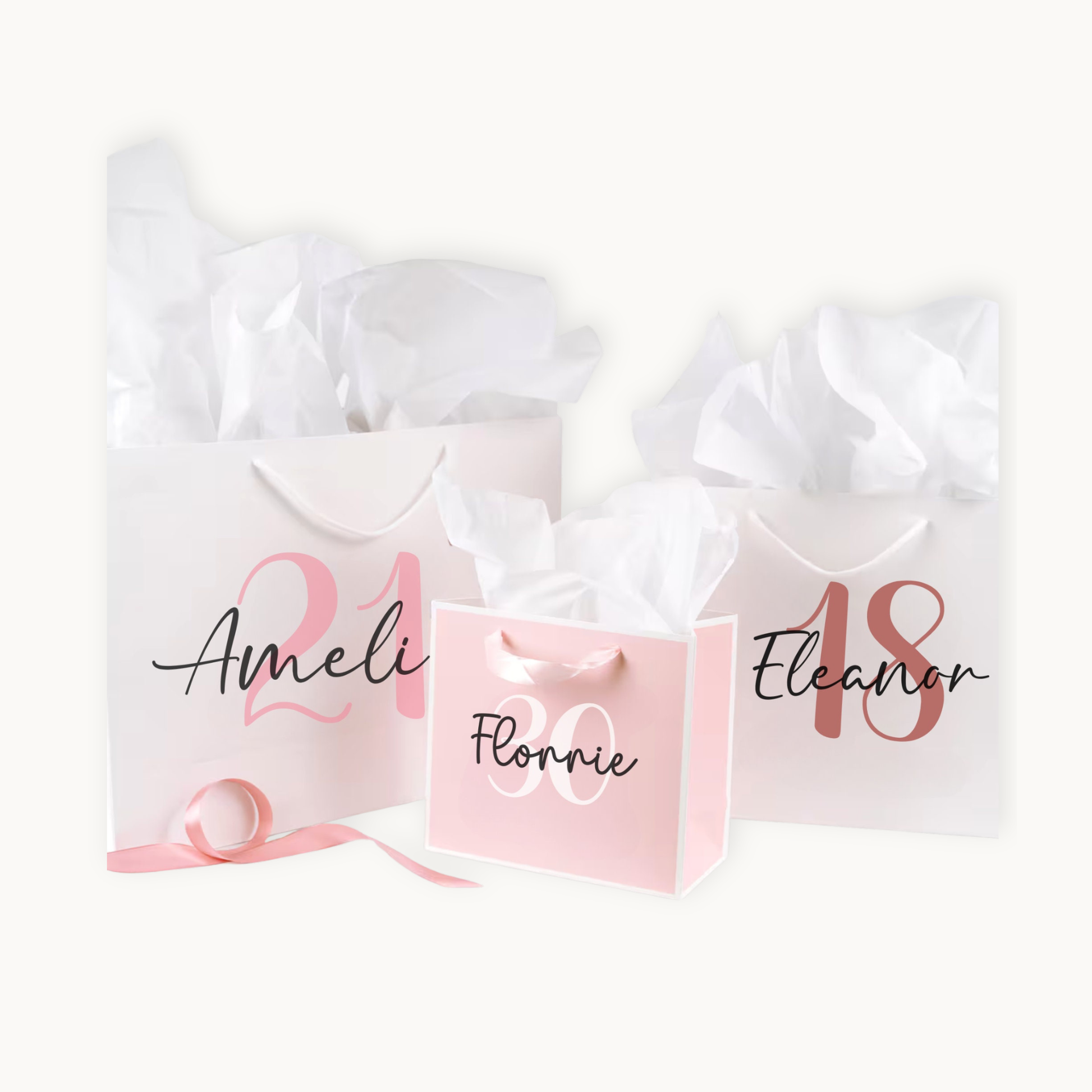 3 gift bags printed with milestone age and name, 2 white and one pink gift bag