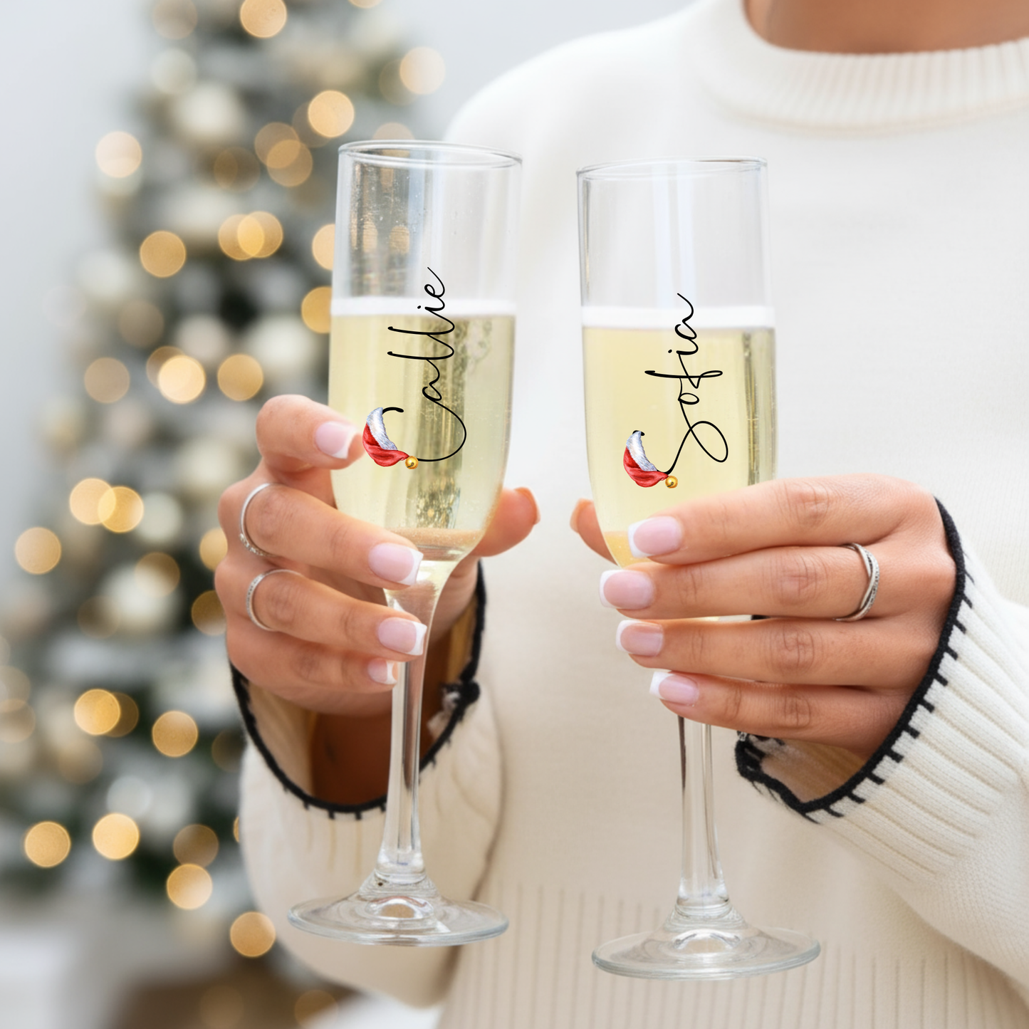1️⃣ Personalised Christmas prosecco flutes held by woman in festive jumper – Callie Keepsakes
