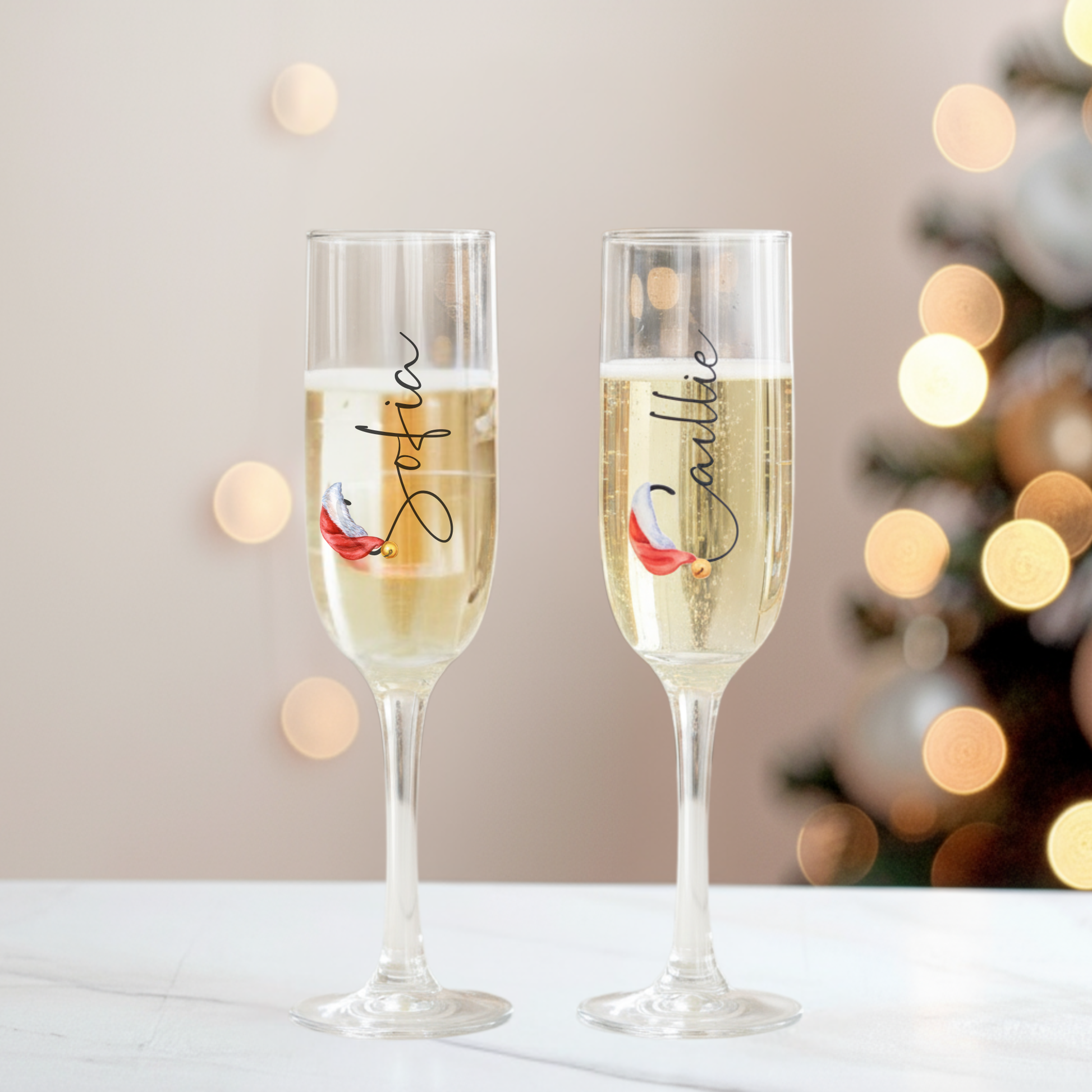 Two personalised prosecco glasses with blurred Christmas tree lights – Callie Keepsakes