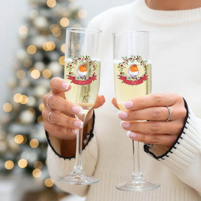 Two glasses of champagne held by a person with a blurred Christmas tree in the background