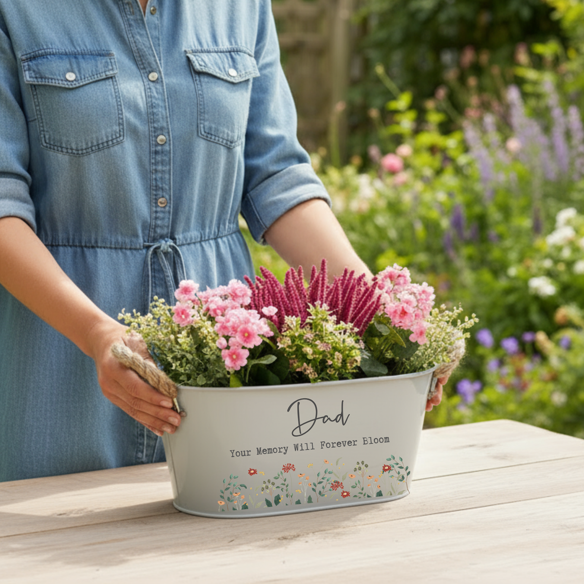Person holding a planter with flowers in a garden setting
