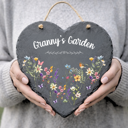 Personalised heart slate sign reading Granny’s Garden with wildflowers and robin, held in hands, garden plaque.