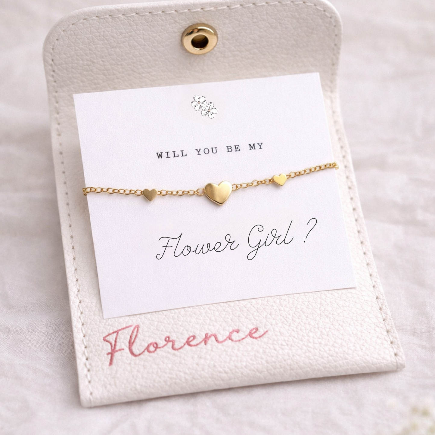 Gold bracelet on a card with 'Will You Be My Flower Girl?' text on a white background