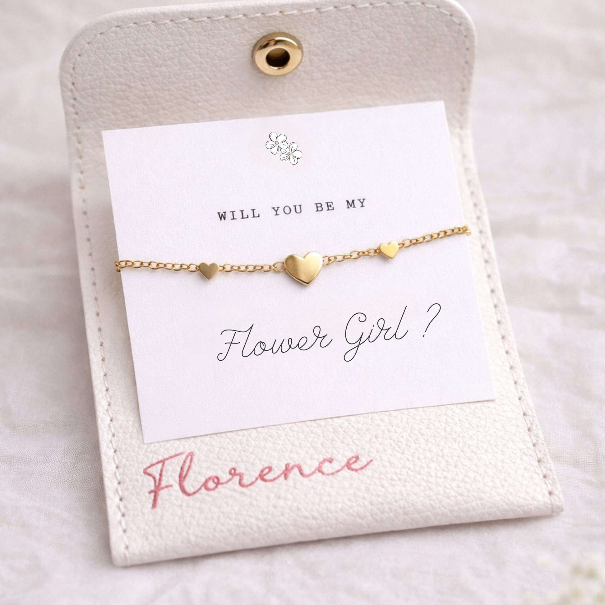 Gold bracelet on a card with 'Will You Be My Flower Girl?' text on a white background