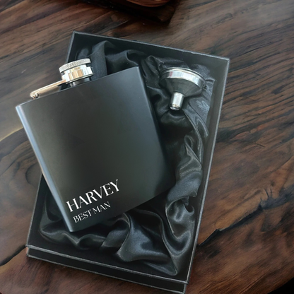 Black flask with 'Harvey Best Man' text in a box on a wooden surface