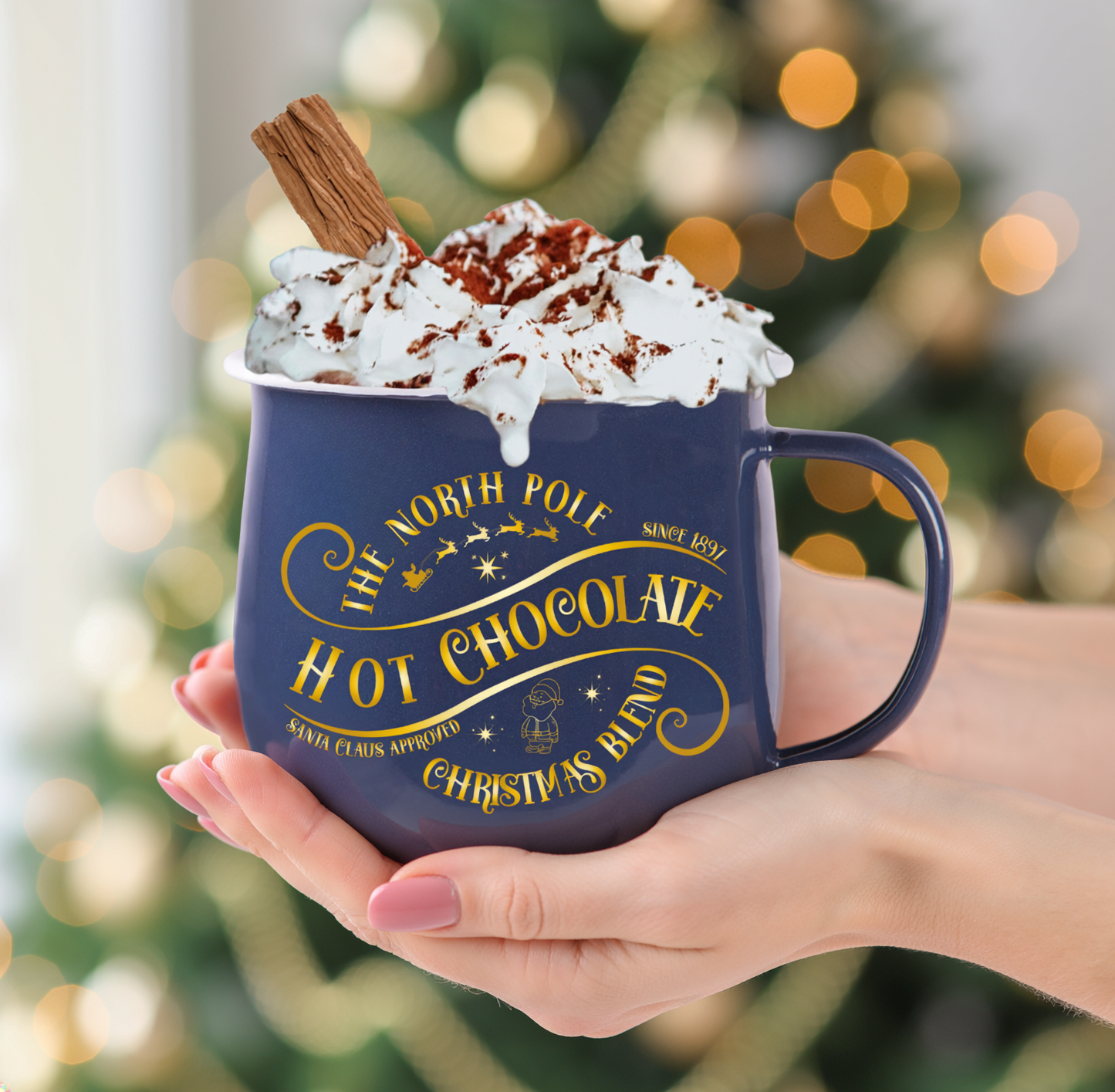 Navy mug with 'Hot Chocolate' text held by a hand against a festive background