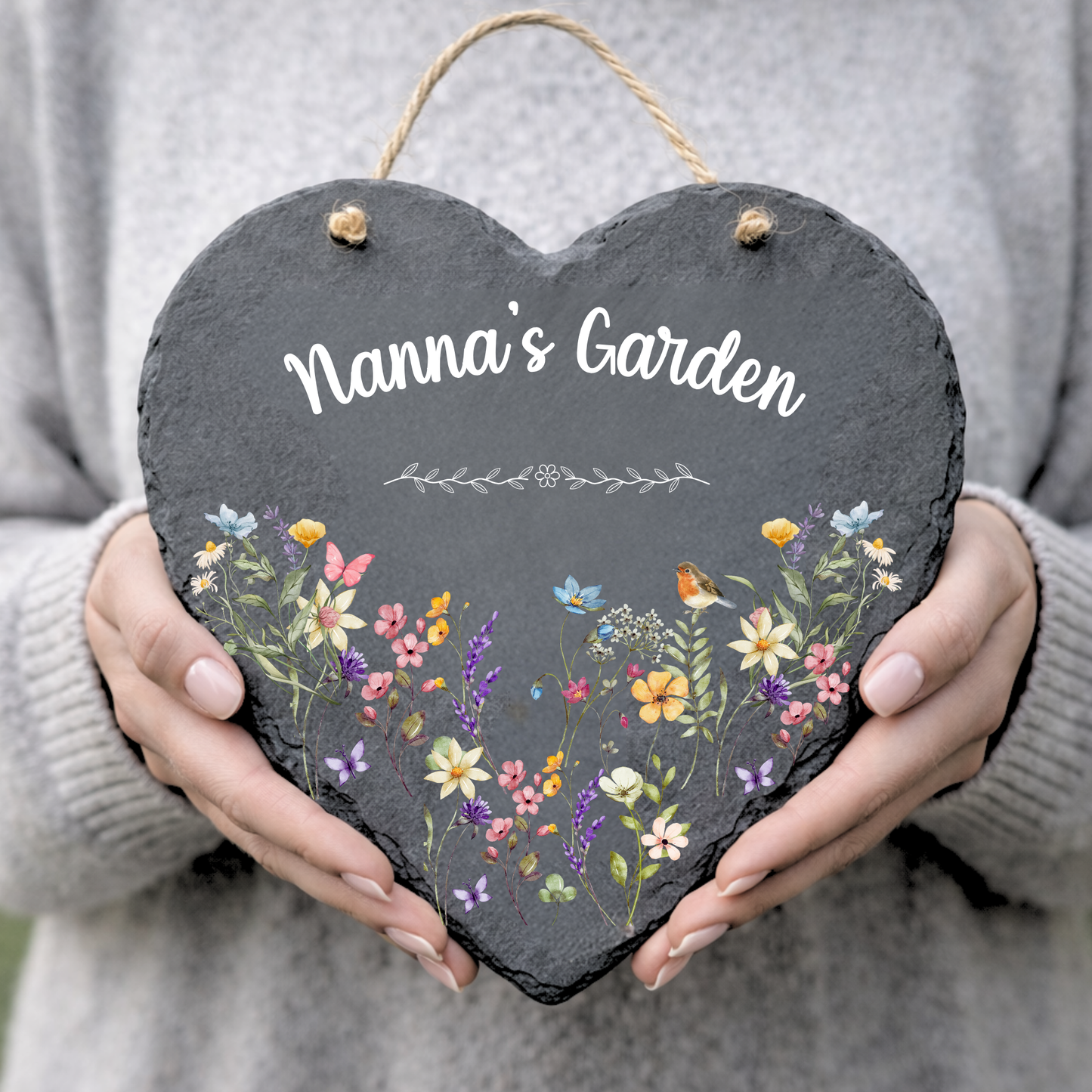 Heart-shaped slate sign with floral design and 'Nanna's Garden' text held by a person.