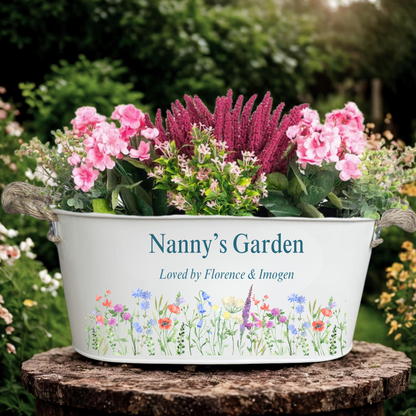Decorative planter with flowers labeled 'Nanny's Garden' on a garden background