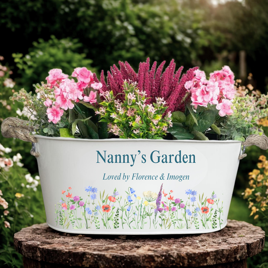 Decorative planter with flowers labeled 'Nanny's Garden' on a garden background