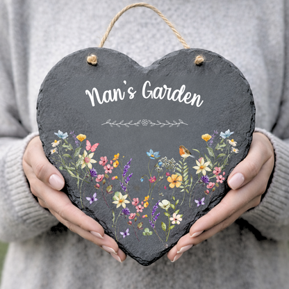 Heart-shaped slate sign with floral design and 'Nan's Garden' text held by a person.
