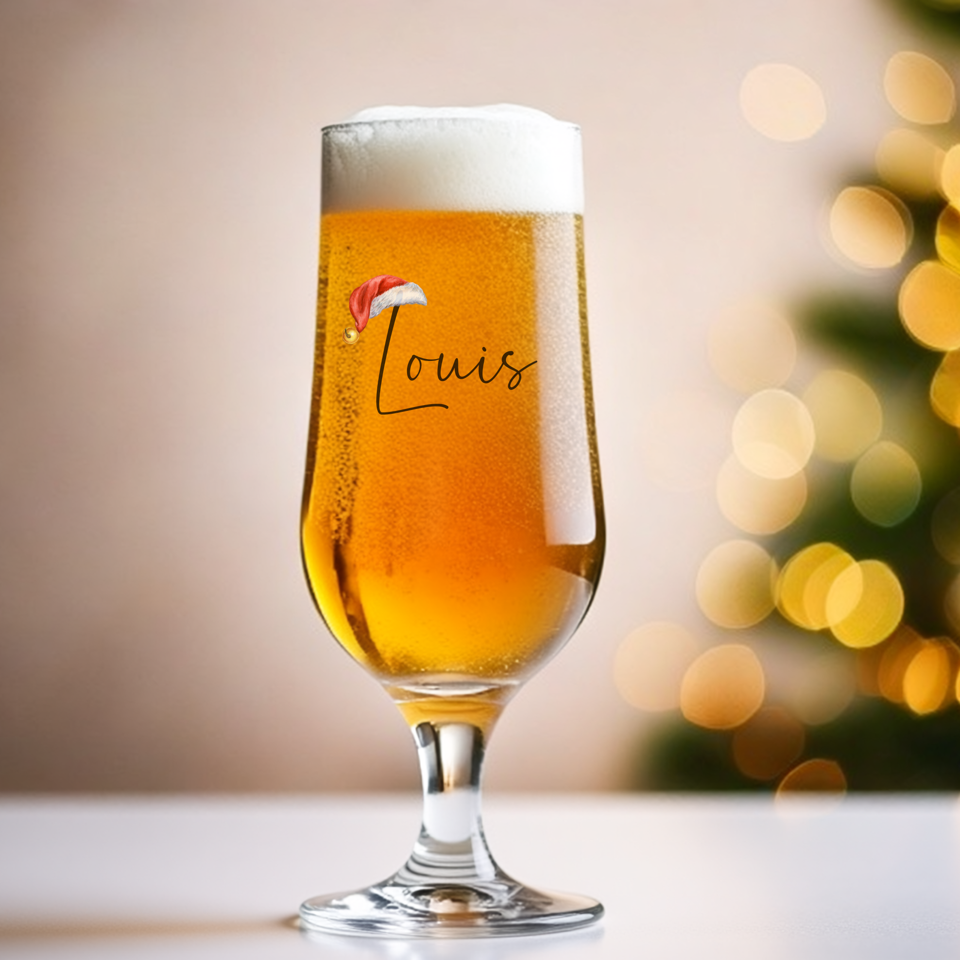 Glass of beer with 'Louis' and a Santa hat design, blurred Christmas tree in the background