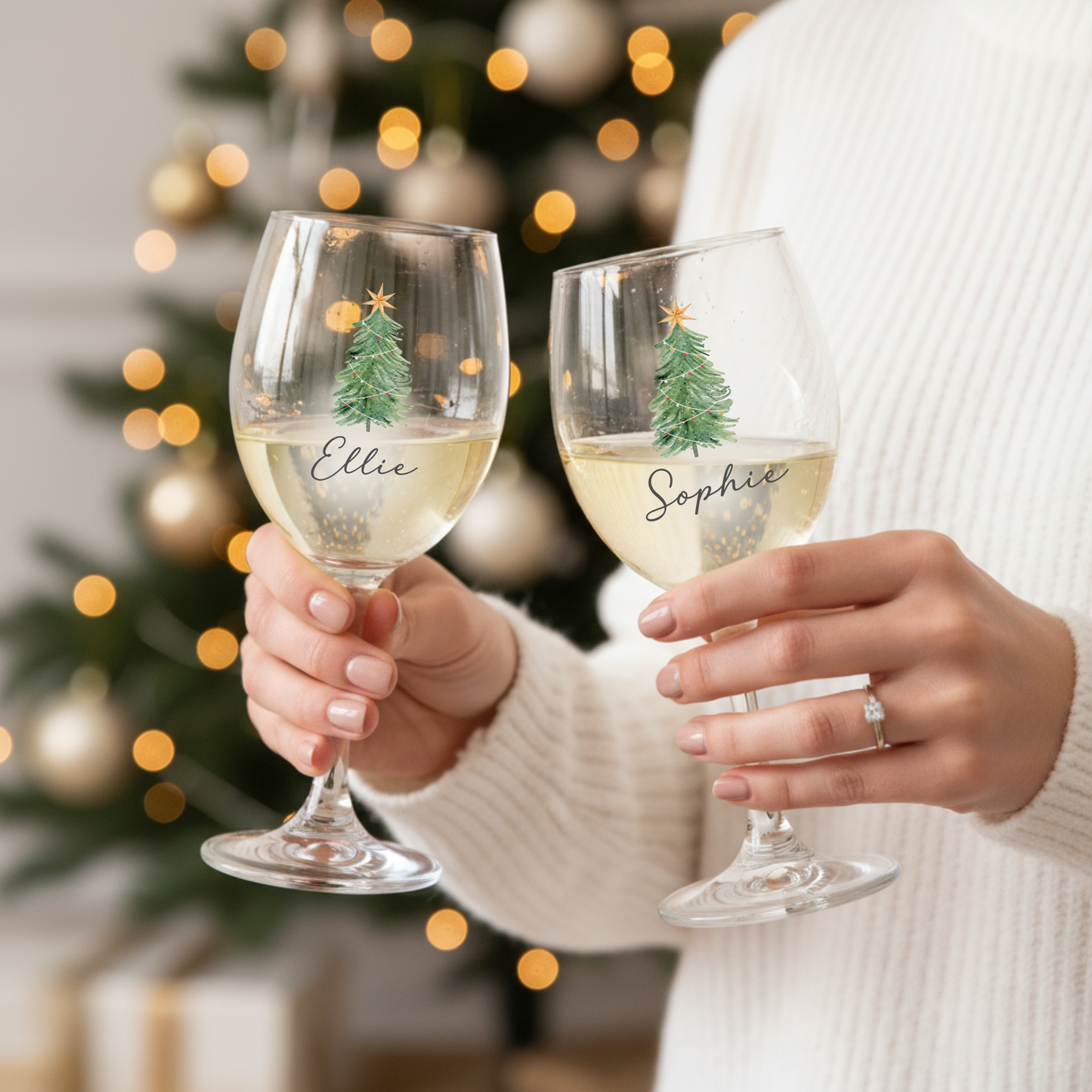 Wine glass with Christmas tree print and personalised name, held in hand