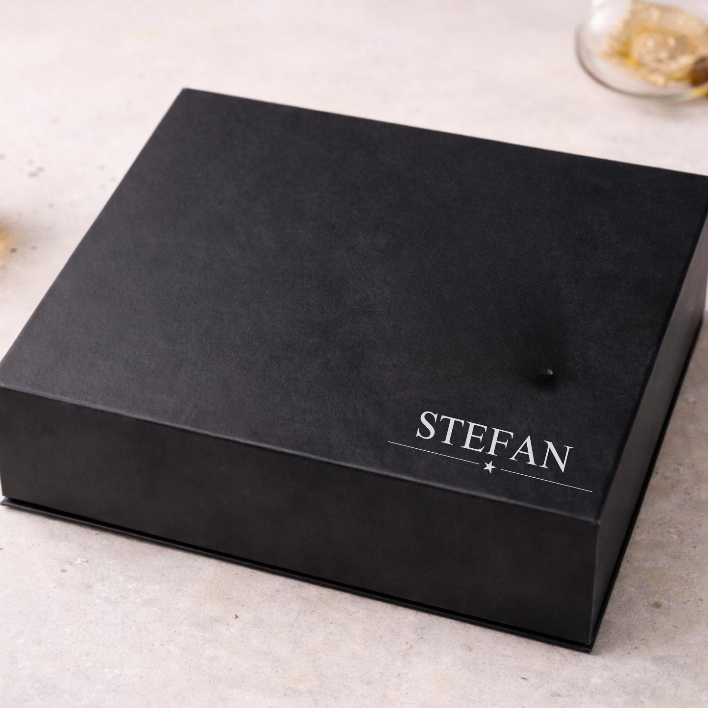 Black magnetic best man gift box with 'STEFAN' branding on a light gray surface