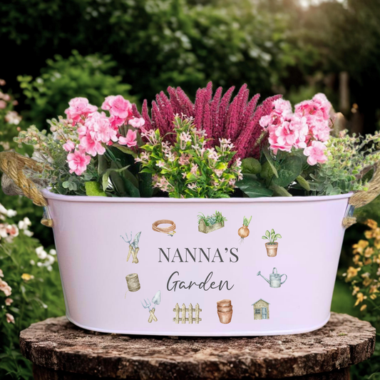 Decorative planter with flowers labeled 'Nanna's Garden' in a garden setting